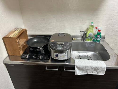 a kitchen counter with a sink and a stove at 高島市一棟貸切可能貸別荘グループファミリーok 大人数でご利用だとお得連泊がお得BBQ可能自転車無料利用可ペット可 駅徒歩10分 in Takashima