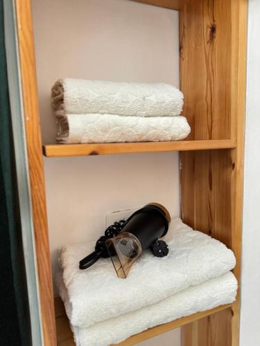 ein Regal mit einigen Handtüchern und einigen Handtüchern in der Unterkunft Studioo Apartment in Tirana