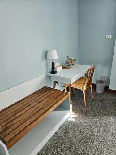 a table and a bench in a room with a lamp at Dusita Residence in Bangkok