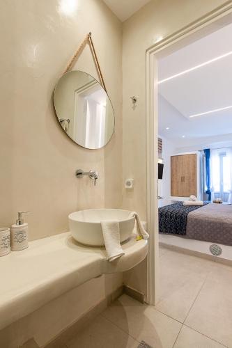 a bathroom with a sink and a mirror and a bed at Santorini Garden Homes in Mesaria
