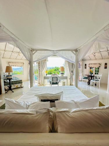 a large white bedroom with a large bed in it at Phu Chaisai Chiang Rai Mountain Resort in Mae Salong Nai
