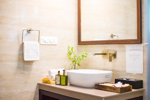 a bathroom with a white sink and a mirror at ELIVAAS 3BHK Plus Attic Cliffside Villa with Scenic Views in Kasauli