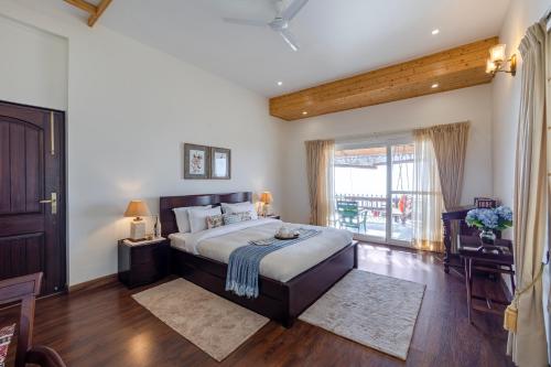 a bedroom with a large bed and a large window at ELIVAAS 3BHK Plus Attic Cliffside Villa with Scenic Views in Kasauli