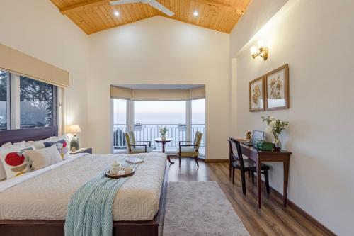 a bedroom with a bed and a table with a desk at ELIVAAS 3BHK Plus Attic Cliffside Villa with Scenic Views in Kasauli