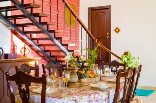 a table with glasses and plants on top of a staircase at ELIVAAS 3BHK Plus Attic Cliffside Villa with Scenic Views in Kasauli