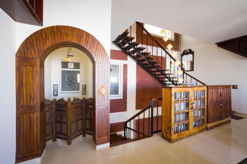 a hallway with a staircase and a room with a door at ELIVAAS 3BHK Plus Attic Cliffside Villa with Scenic Views in Kasauli