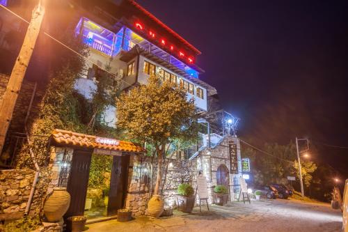 un bâtiment avec des lumières sur son côté la nuit dans l'établissement Chalet Castello, à Neos Panteleimonas