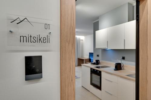 a kitchen with white cabinets and a sign on the wall at Nomads Lux Studios & Business Center in Ioannina