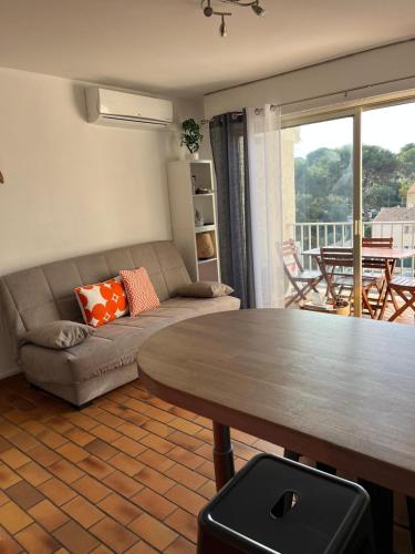 un salon avec un canapé et une table dans l'établissement Élégant Studio au calme 2mn mer Wifi Clim Terrasse parking, à Six-Fours-les-Plages