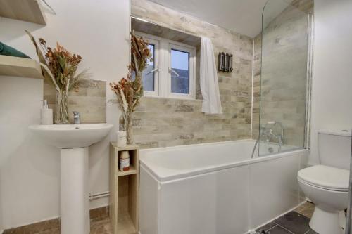 a bathroom with a tub and a sink and a toilet at Holiday Home in Central Southsea in Portsmouth