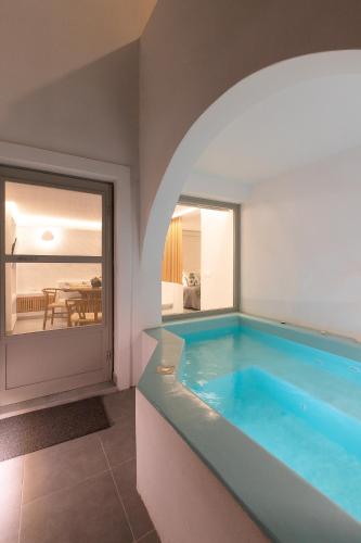 a swimming pool in a room with a view of the ocean at Santorini Garden Homes in Mesaria