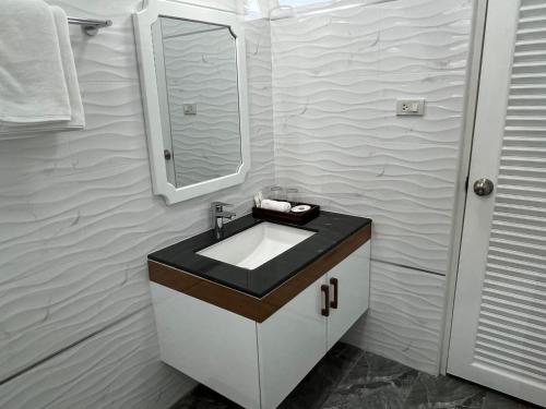 a bathroom with a sink and a mirror at Dusita Residence in Bangkok