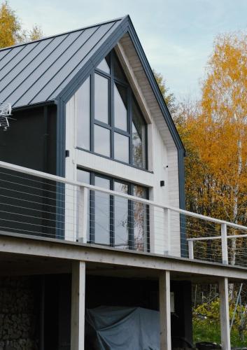 a house with a black roof and a balcony at Domek BEZDECH in Bodzentyn