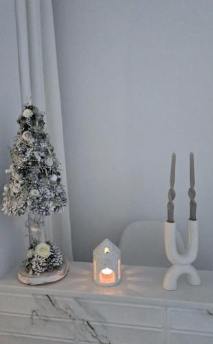 a white table with a christmas tree and a candle at Villa Marmont Karlovac Luksuzni Smještaj na Top Lokaciji s Parkingom i Self Check inom in Karlovac