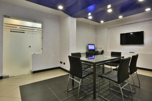 a conference room with a table and chairs and a tv at Central Park Hotel Modena in Modena