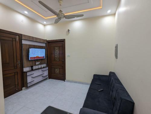 a living room with a couch and a tv at Executive Oasis in Mūsapur
