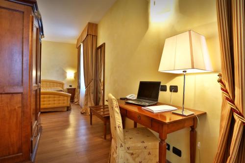 a room with a desk with a laptop on it at Central Park Hotel Modena in Modena