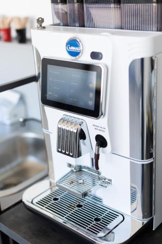 a white coffee machine sitting on a counter at Associazione Garage24 Aps Ets in Portoferraio