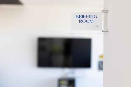 a sign that reads briefing room with a tv at Associazione Garage24 Aps Ets in Portoferraio