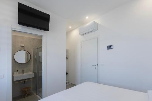 a white bathroom with a sink and a mirror at Associazione Garage24 Aps Ets in Portoferraio