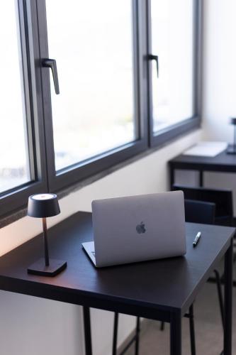 a laptop computer sitting on a table with windows at Associazione Garage24 Aps Ets in Portoferraio