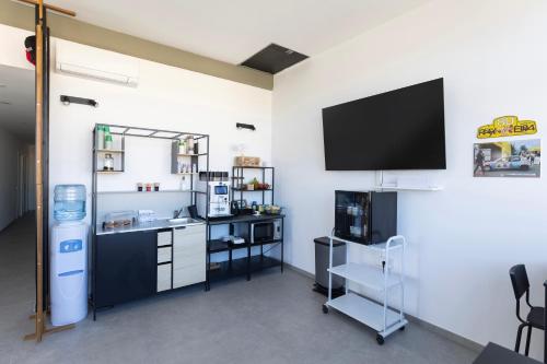 a room with a tv on a white wall with a counter at Associazione Garage24 Aps Ets in Portoferraio