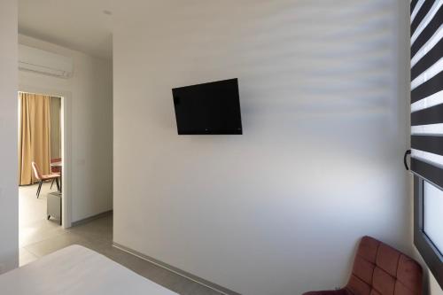a living room with a tv on a white wall at Associazione Garage24 Aps Ets in Portoferraio
