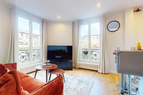 a living room with a couch and a tv at F2 Trocadero in Paris