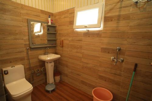 a bathroom with a toilet and a sink and a mirror at Doon Classic A in Rājpur