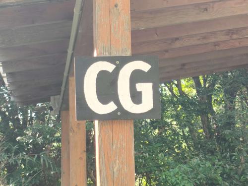 a sign on a wooden pole that says cg at 南伊豆ランドホピア Minami Izu Land Hopia in Minamiizu