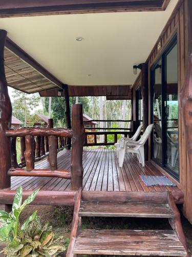 a large wooden deck with a chair on it at Kohjum Freedom Resort in Ko Jum