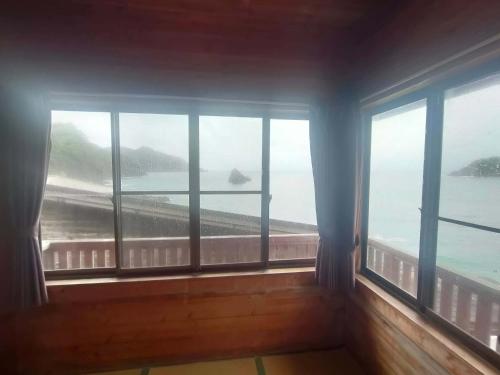 a room with windows with a view of the ocean at 南伊豆ランドホピア Minami Izu Land Hopia in Minamiizu