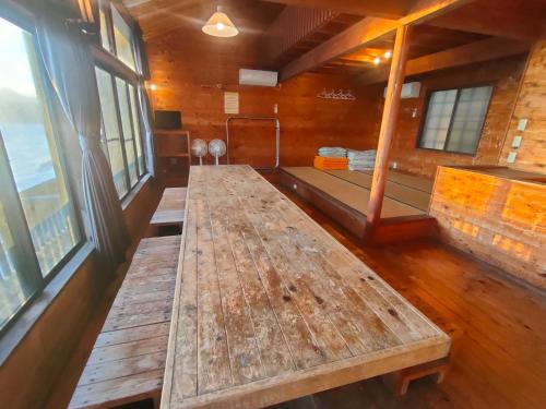 a large wooden table in a room with windows at 南伊豆ランドホピア Minami Izu Land Hopia in Minamiizu