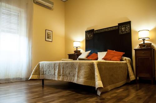 een slaapkamer met een groot bed met oranje kussens bij Casa Bellavista in Noto