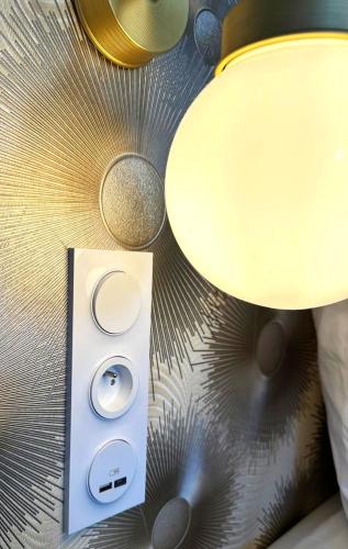 un interrupteur lumineux et une lampe sur une paroi dans l'établissement Studio Alba - Confort moderne - Terrasse - Parking gratuit - Non fumeur, à Fumel
