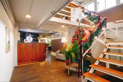 a living room with a staircase with a christmas tree at Hotel PAPA Bangkok in Bangkok