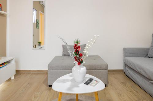 a vase with flowers on a table in a living room at Baracca Apartment in Massa Lombarda