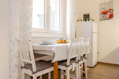 a kitchen with a table with chairs and a white refrigerator at Baracca Apartment in Massa Lombarda