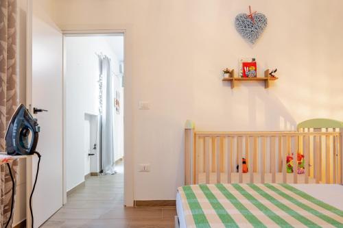 a childs bedroom with a crib and a heart on the wall at Baracca Apartment in Massa Lombarda