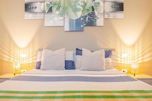 a bedroom with a bed with three paintings on the wall at Baracca Apartment in Massa Lombarda