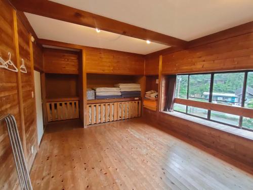 a room with wooden walls and a large window at 堂ヶ島ランドホピア Dogashima Land Hopia in Nishiizu