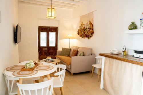 a kitchen and a living room with a table and chairs at Casablanca Vejer Baño Termal in Vejer de la Frontera