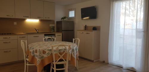 une cuisine avec une table et des chaises ainsi qu'une cuisine avec une table et une fenêtre dans l'établissement Les appartements de Mansart, à Chambray-lès-Tours