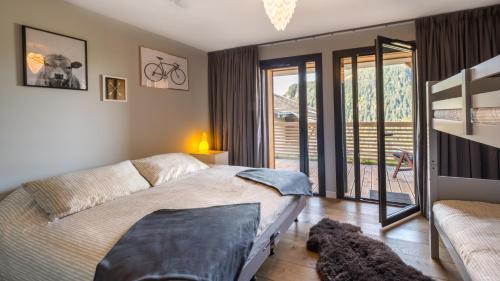 une chambre avec un lit et un balcon dans l'établissement Apt 360 n17 - BO Immobilier - Châtel, à Châtel