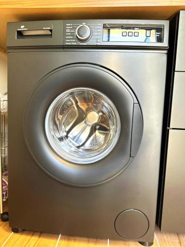a washer and dryer sitting in a kitchen at Studio Preto - Confort moderne - Terrasse - Parking gratuit - Non fumeur in Fumel