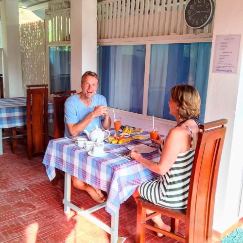 a man and a woman sitting at a table at Thusara Guesthouse in Mirissa