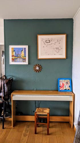 un mur bleu avec une table en bois dans une chambre dans l'établissement T3 lumineux avec vue panoramique - Point du Jour, à Lyon