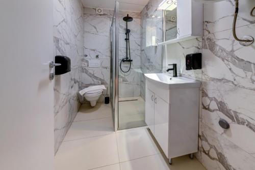 a bathroom with a shower and a sink and a toilet at V APARTMENT 2 Futog in Futog