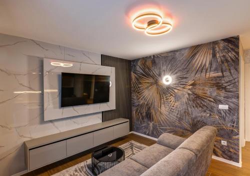 a living room with a couch and a tv at V APARTMENT 2 Futog in Futog