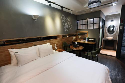 晋州市Hotel Kkuljam Stay的卧室里有一张白色的大床和一张书桌